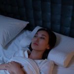 An Asian woman lying awake in bed, reflecting on her thoughts during a sleepless night.